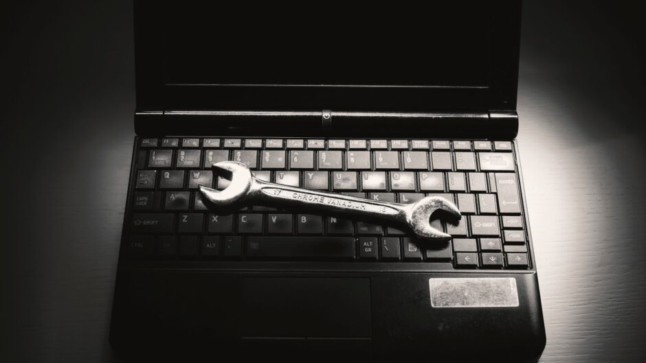laptop na którym leży klucz do naprawy