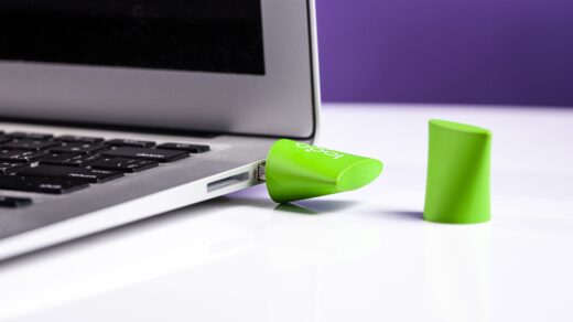 Zielony pendrive reklamowy podpięty do laptopa