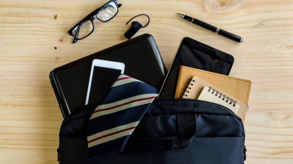 Elegancja, czarna torba na laptopa lezy na drewnianym biurku