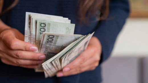 Kobieta trzyma w dłoniach pieniądze które pożyczyła w banku