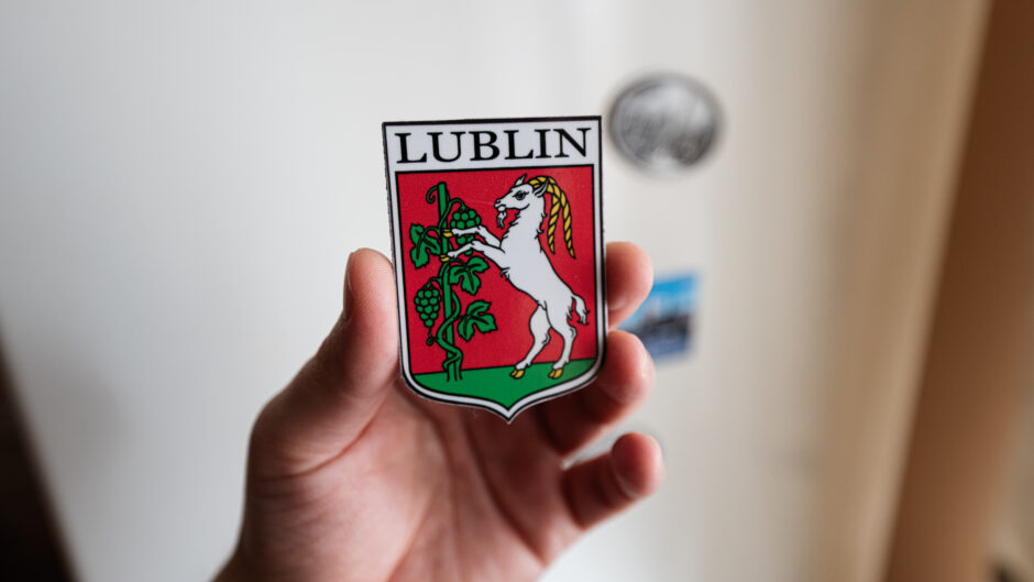 Dłoń trzymająca plakietkę z herbem Lublina