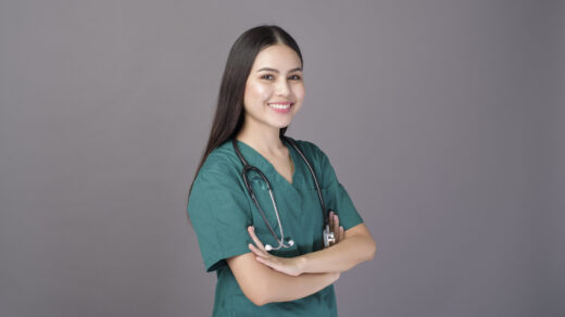 Uśmiechnięta pielęgniarka, ubrana w zielony fartuch