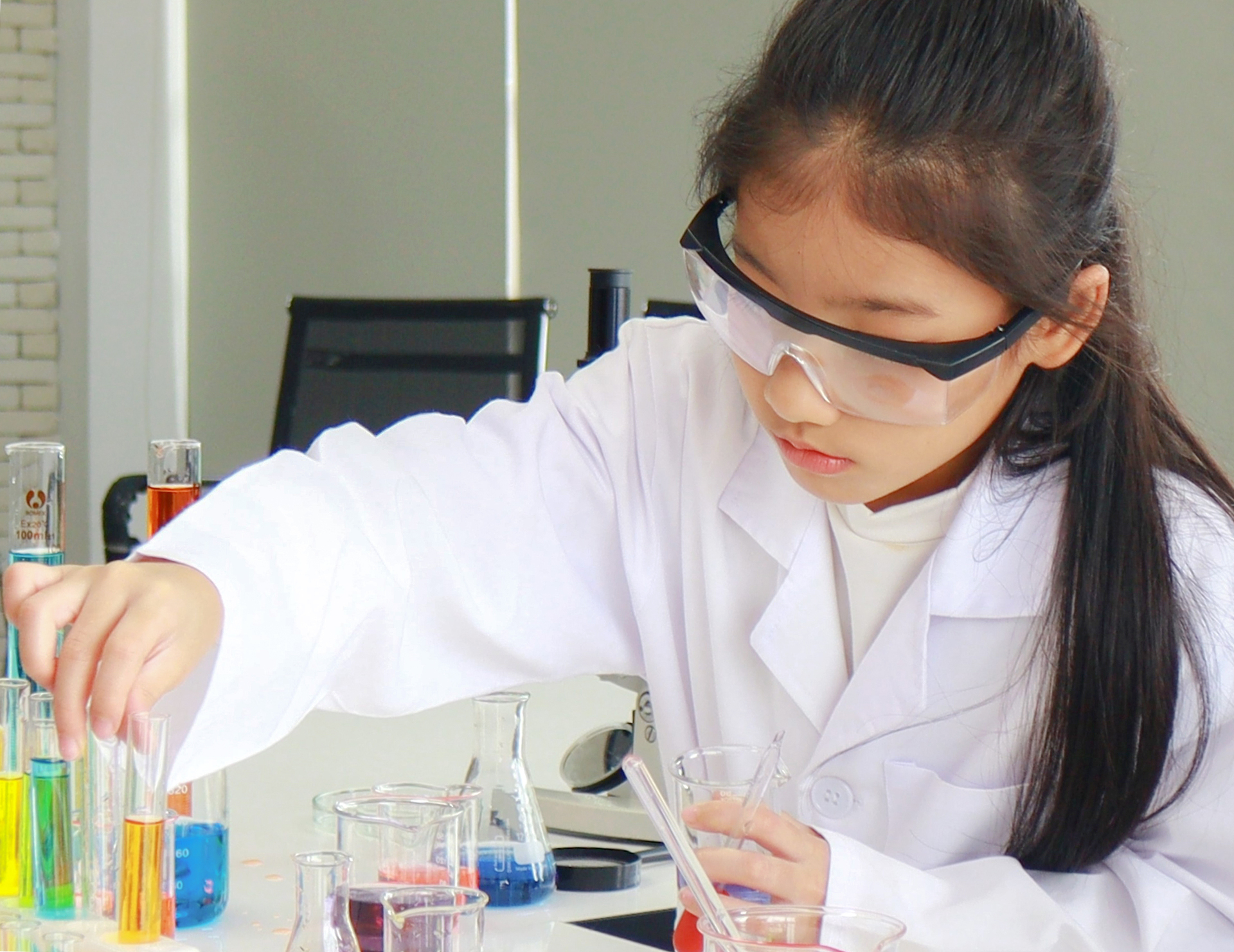 Na obrazku widać zainteresowaną nauką dziewczynkę, która bierze udział w zajęciach chemicznych. Jest to idealne rozwiązanie dla dzieci, które chcą poszerzać swoją wiedzę i zdobywać nowe umiejętności. Zajęcia chemiczne pozwalają na eksperymentowanie i odkrywanie fascynującego świata nauki. Obrazek przedstawia aktywną uczestniczkę zajęć, która z pełnym zaangażowaniem pochłonięta jest swoimi badaniami. To znakomita inspiracja dla wszystkich, którzy chcą rozwijać swoją pasję do nauki i odkrywać nowe obszary wiedzy.