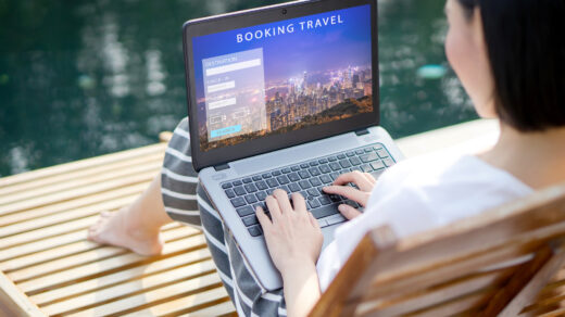 Kobietę siedzącą przed laptopem i korzystającą z biura podróży online