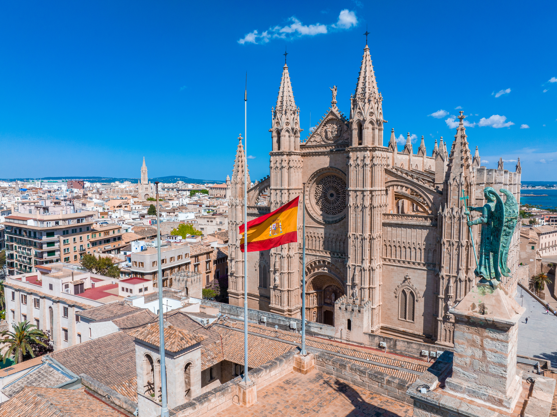 Hiszpańskie miasto z majestatycznym kościołem dominującym nad panoramą i flagą kraju