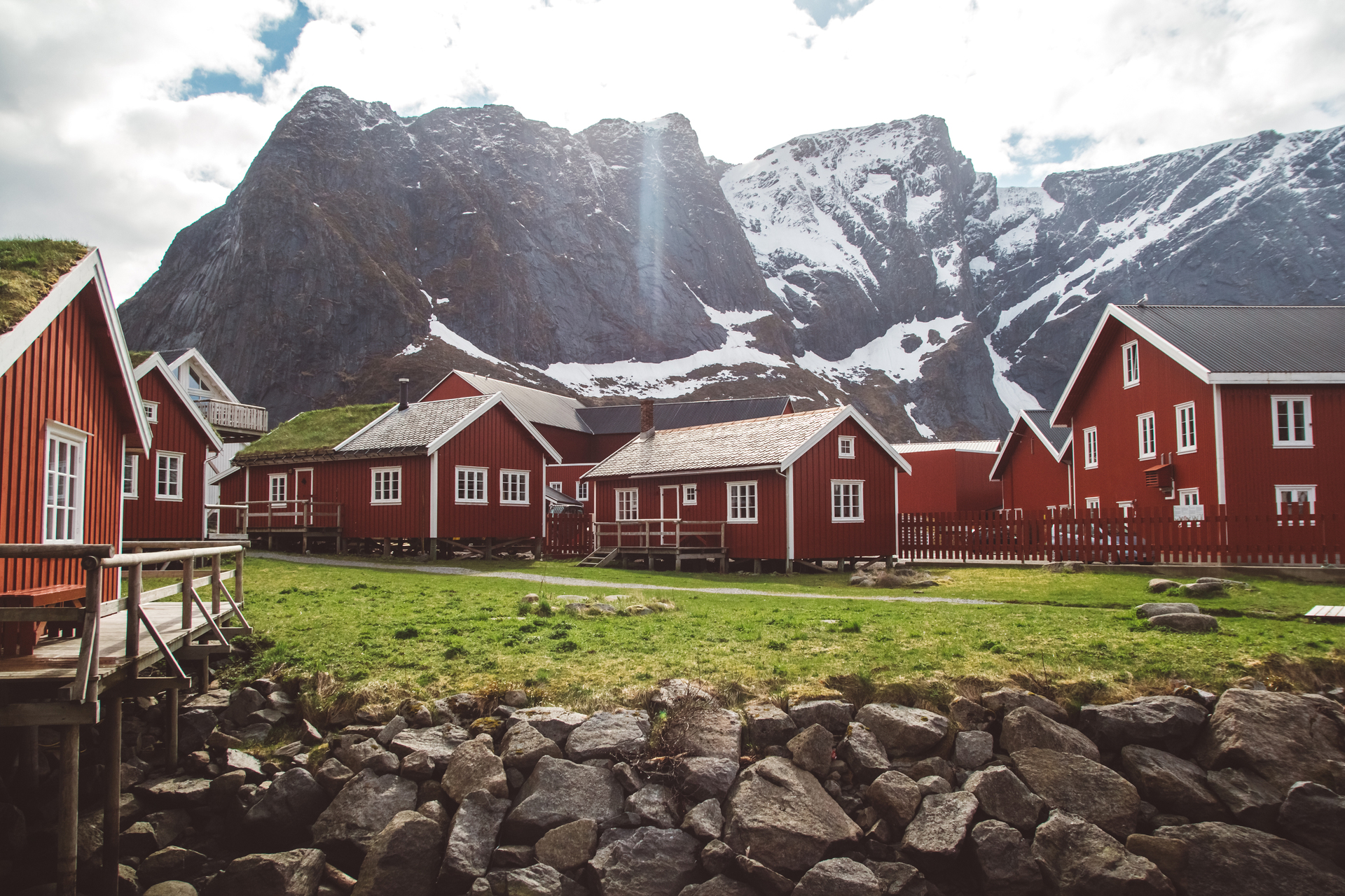 Malowniczy krajobraz Norwegii z charakterystycznymi czerwonymi domkami i górami w tle