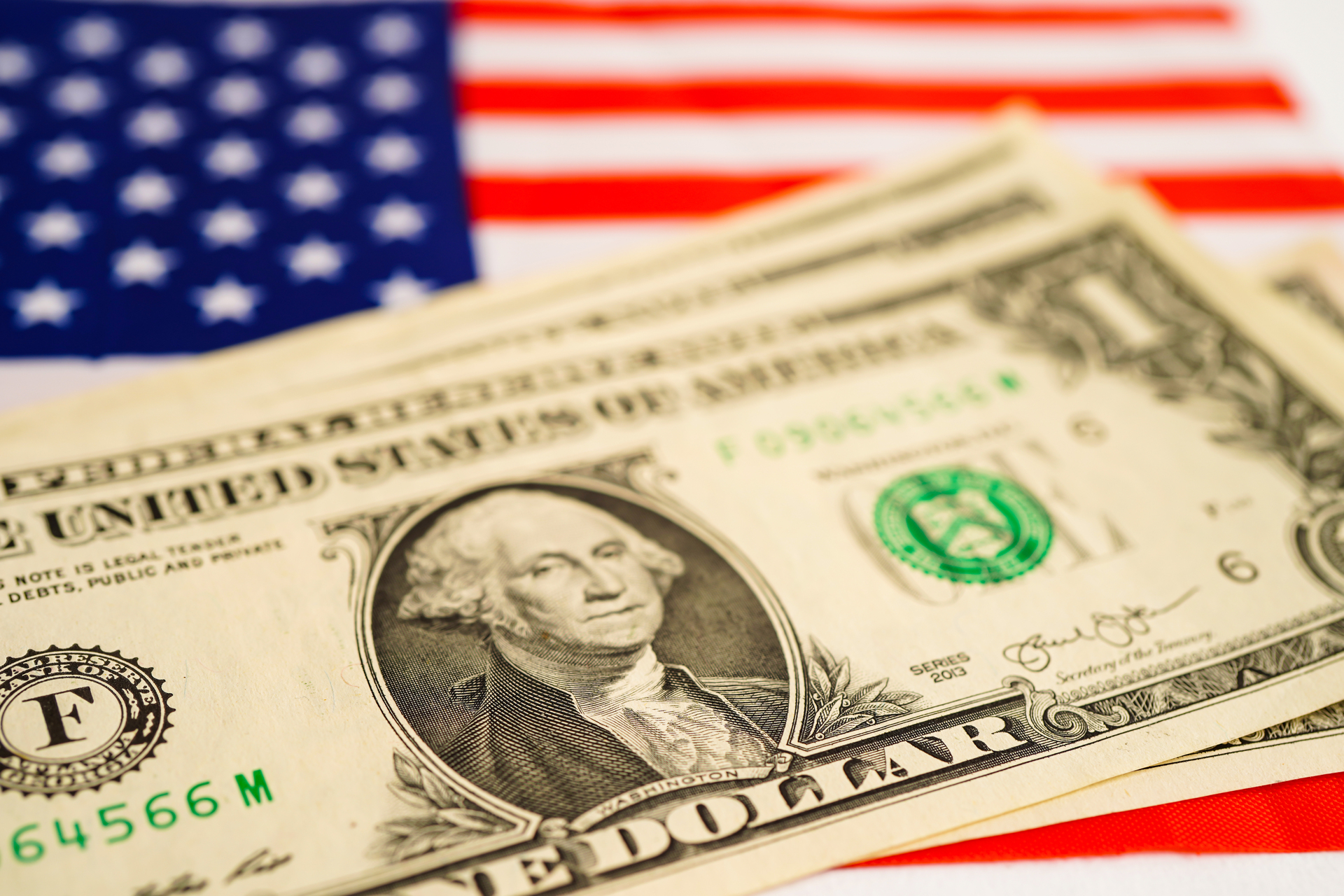 Pojedynczy dolar amerykański, starannie ułożony na fladze Stanów Zjednoczonych