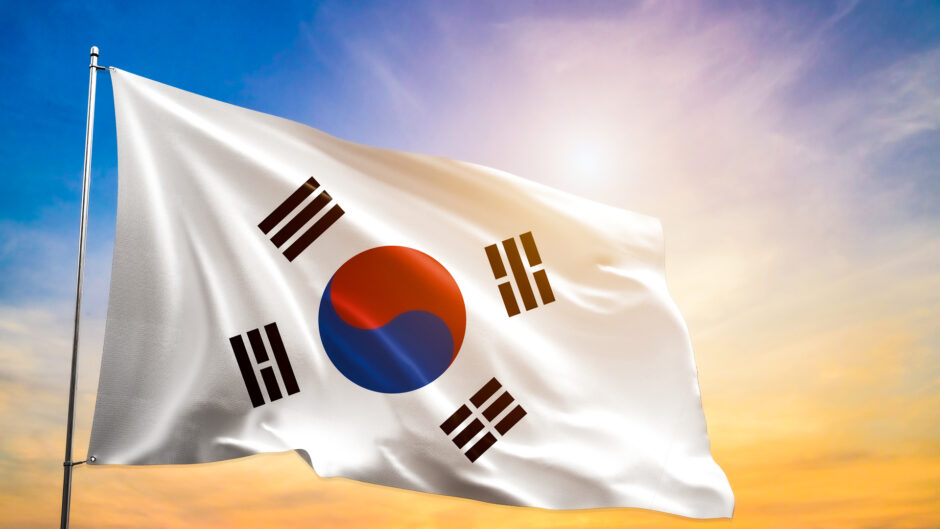 Flaga Korei Południowej, składającą się z trzech elementów: biało-niebieskiej tarczy na czerwonym tle