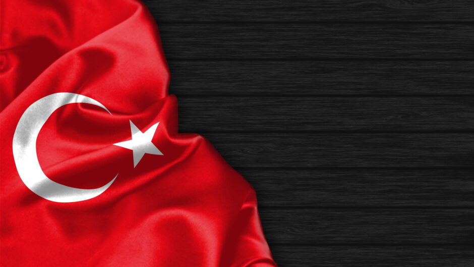 Flaga Turcji, z charakterystycznym czerwonym tłem i białym półksiężycem oraz gwiazdą na czarnym tle
