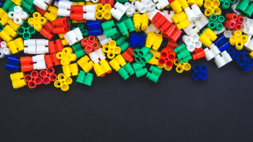 Kolorowe klocki LEGO rozrzucone na czarnym stole