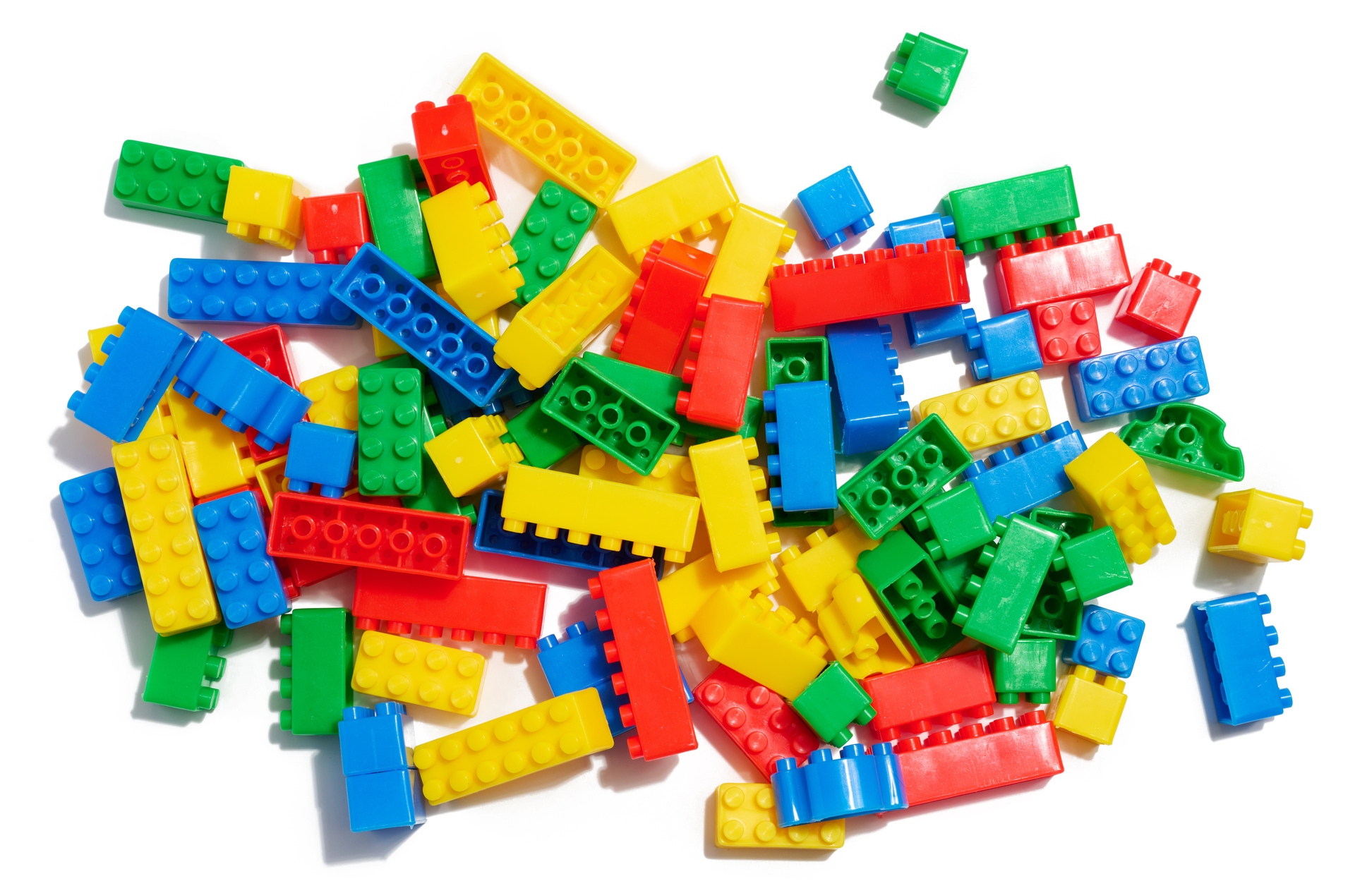Zestaw kolorowych klocków LEGO, leżących na białym tle