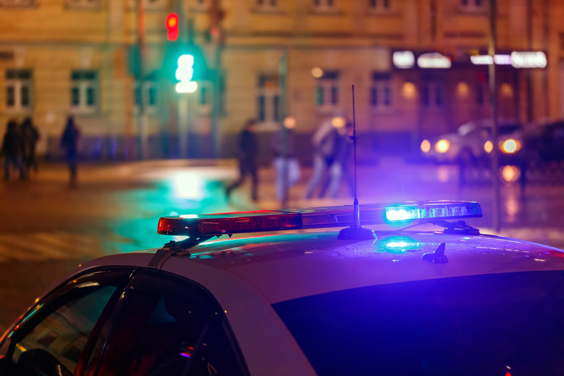 Intensywne, migające światła policyjne, umieszczone na dachu pojazdu policyjnego w nocy