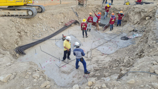 Zespół budowlańców w trakcie intensywnej pracy na budowie, wspólnie realizujących projekt