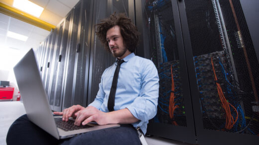 Informatyk, reprezentujący męski zawód, w pełni skoncentrowany na pracy z komputerem