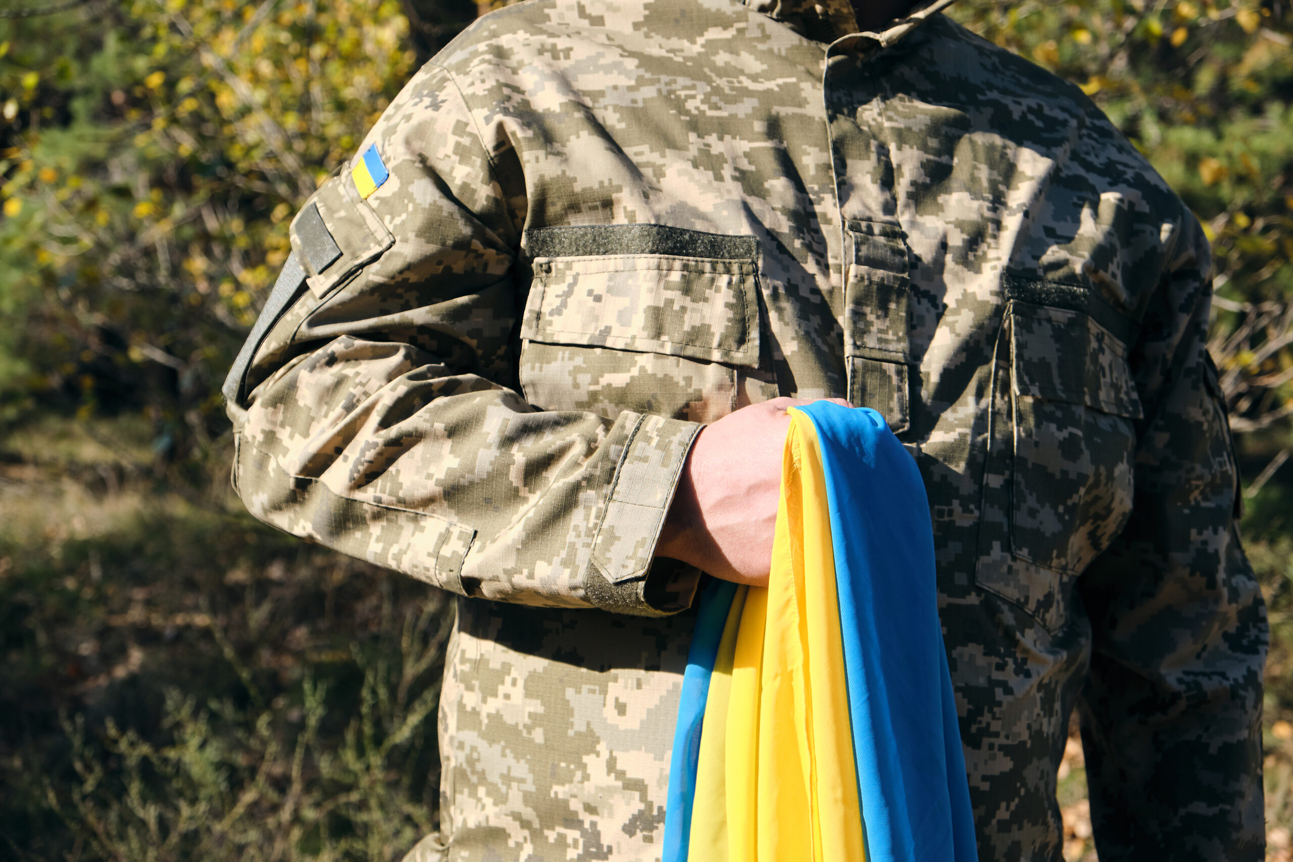Mundur wojskowy ozdobiony ukraińskimi flagami, które dumnie prezentują narodowe barwy