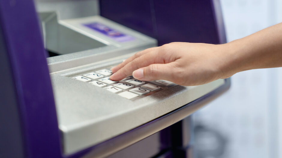 Kobieta korzystająca z bankomatu jako jednej z usług bankowych