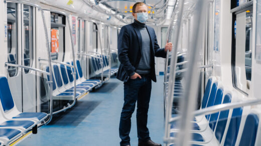 Mężczyzna stojący w transporcie publicznym, który to transport jest przykładem substytutu