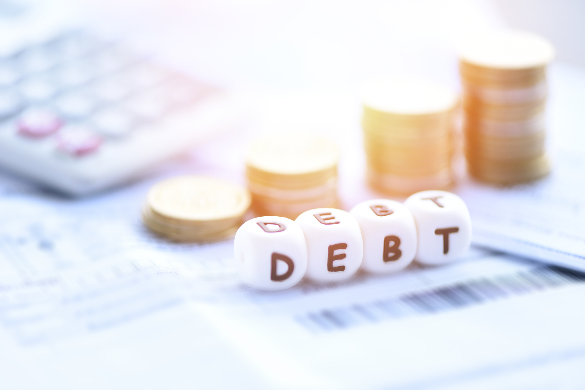 Kostki ułożone w słowo "debt", które symbolizuje dług publiczny