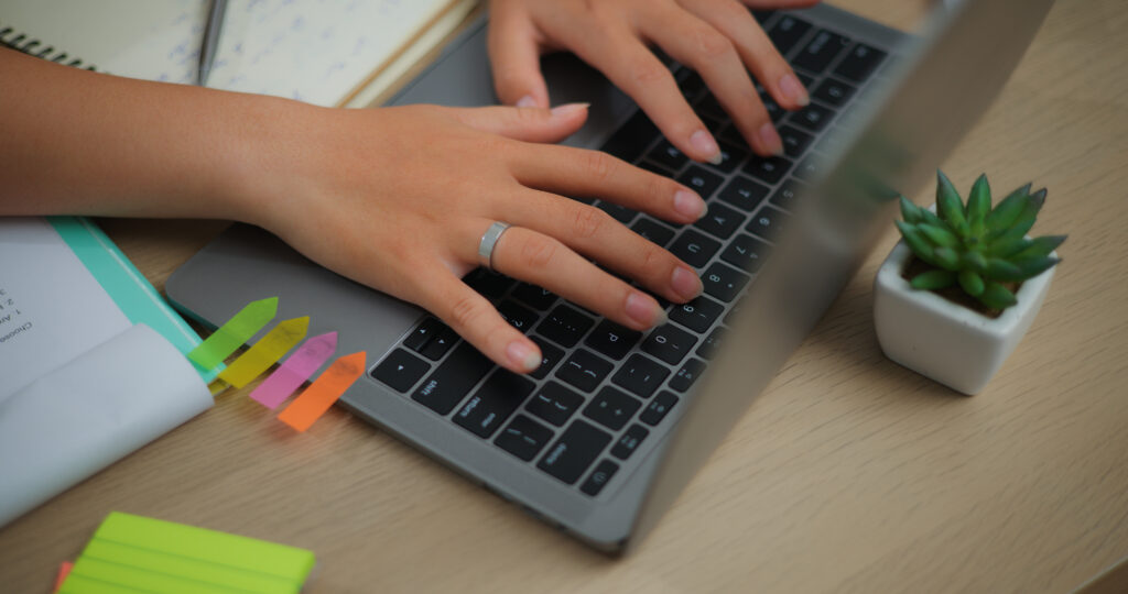 Dłonie redaktora na klawiaturze laptopa